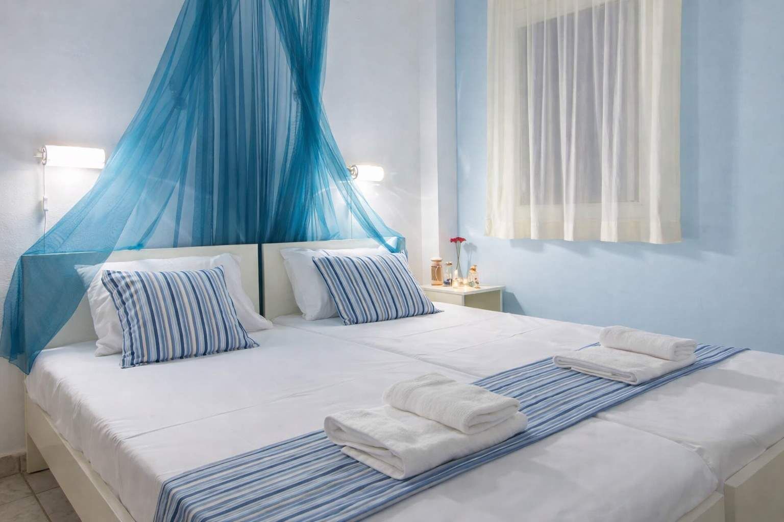 Bright and relaxing bedroom featuring a comfortable double bed with soft linens, airy curtains, and calming décor, creating a peaceful space ideal for restful nights