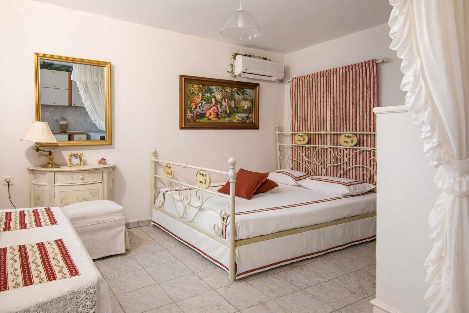 Bright and inviting bedroom featuring a charming iron bed, soft linens, and elegant décor. The space offers a warm and relaxing atmosphere, making it perfect for unwinding after a day exploring 