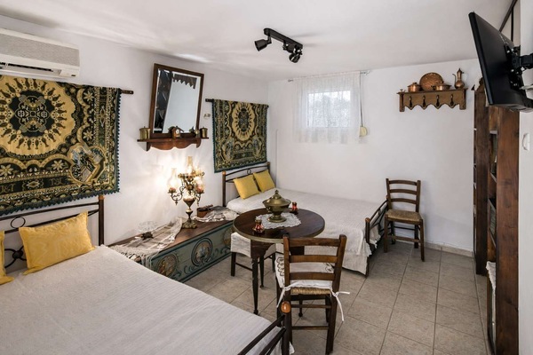 Charming studio with two twin beds, vintage décor, and warm details, offering a unique and cozy atmosphere inspired by traditional design