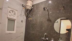 A modern bathroom with a toilet, sink, and shower. - Kailas Residency (Varanasi)