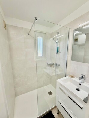 Een douche, handdoeken, zeep, shampoo