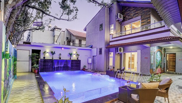 A hotel with a swimming pool, outdoor seating, and a balcony. - Alaya Stays Nest 4BHK villa with Pool  (Lonavala)