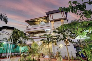 A multi-story building with a covered balcony and potted plants. - Alaya Stays Nest 4BHK villa with Pool  (Lonavala)