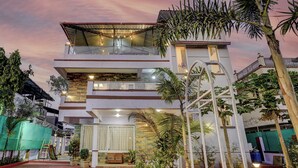 A multi-story building with a balcony, a covered area, and a staircase. - Alaya Stays Nest 4BHK villa with Pool  (Lonavala)