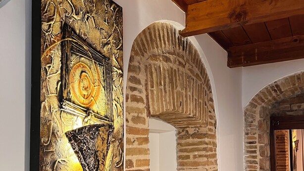 A room with a large abstract painting, a stone archway, and a wooden ceiling. - Vacation house with Terrace in the historic center of Bernalda, 10 minutes from the sea. (Bernalda)