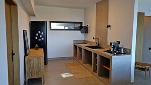 Een moderne keuken met een inbouwoven, een koffieapparaat en een raam boven de gootsteen.