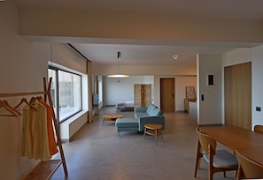 Ein modernes Wohnzimmer mit Sofa, Couchtisch und Esstisch.