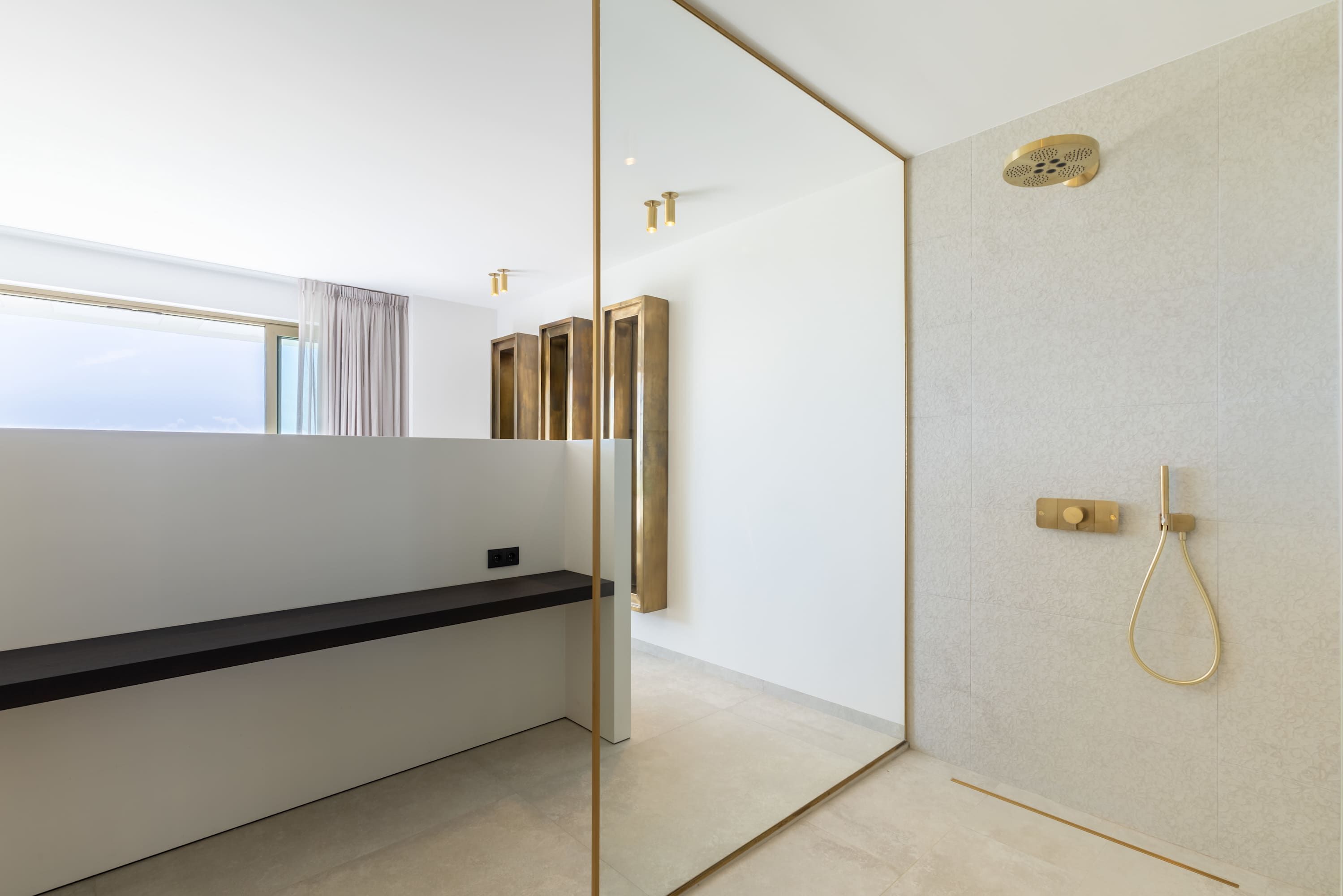 A modern bathroom with a shower, a vanity with a mirror, and a window.