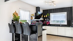 Una cocina moderna con barra, un ventanal grande y una decoración en blanco y negro.