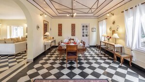 A dining area with a checkered floor, a central table set for four, and a chandelier. - Alaya Stays Chalet Vie 3 BHK Villa (Kasauli)
