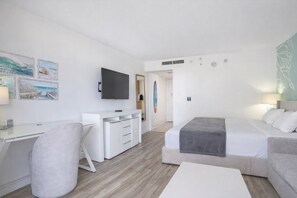 A modern hotel room with a bed, a desk, a chair, a TV, and artwork on the walls. - 1 Free Parking!! Spacious Studio High Floor in Palms at Waikiki. (Honolulu)