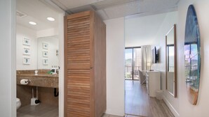 Un baño moderno con un tocador de madera, inodoro y lavamanos.