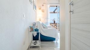 Ein Schlafzimmer mit Bett, Nachttisch, Lampe und Blick ins Freie.