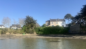 En flod med hus och träd i bakgrunden.
