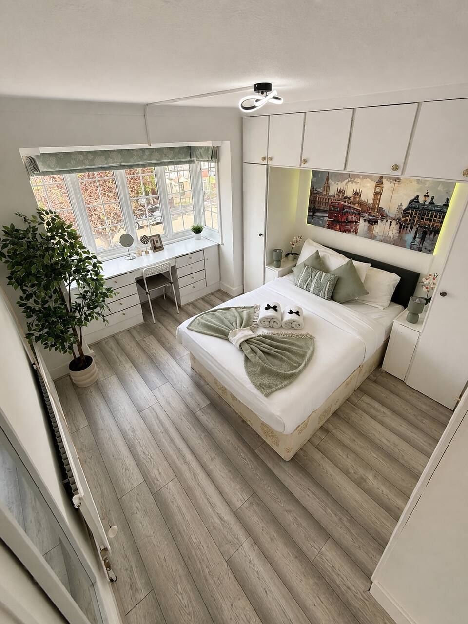 Ein Schlafzimmer mit einem Bett, einem Schreibtisch und einem großen Fenster.
