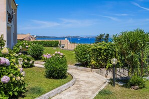Un vialetto fiorito conduce a un edificio con vista sul mare.