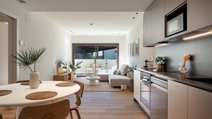 Une cuisine moderne avec un coin repas, un canapé et une vue sur l’extérieur.