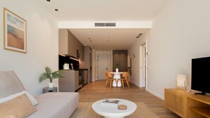 Un salon moderne comprenant un canapé, une table basse, un meuble pour la télévision et un coin repas avec des chaises et une table.