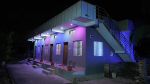 A modern two-story house with a staircase, multiple windows, and outdoor steps. - PremKunj Homestay (Dandeli)