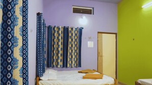 A room with a bed, a wardrobe, and a door. - PremKunj Homestay (Dandeli)