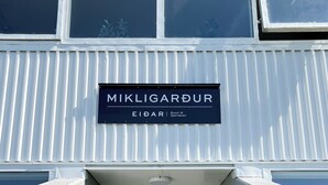 A building entrance with a sign reading 'MIKLIGARDUR EIDAR Hotel & Apartments.' - Eiðar Hostel and Apartments (Eiðar)