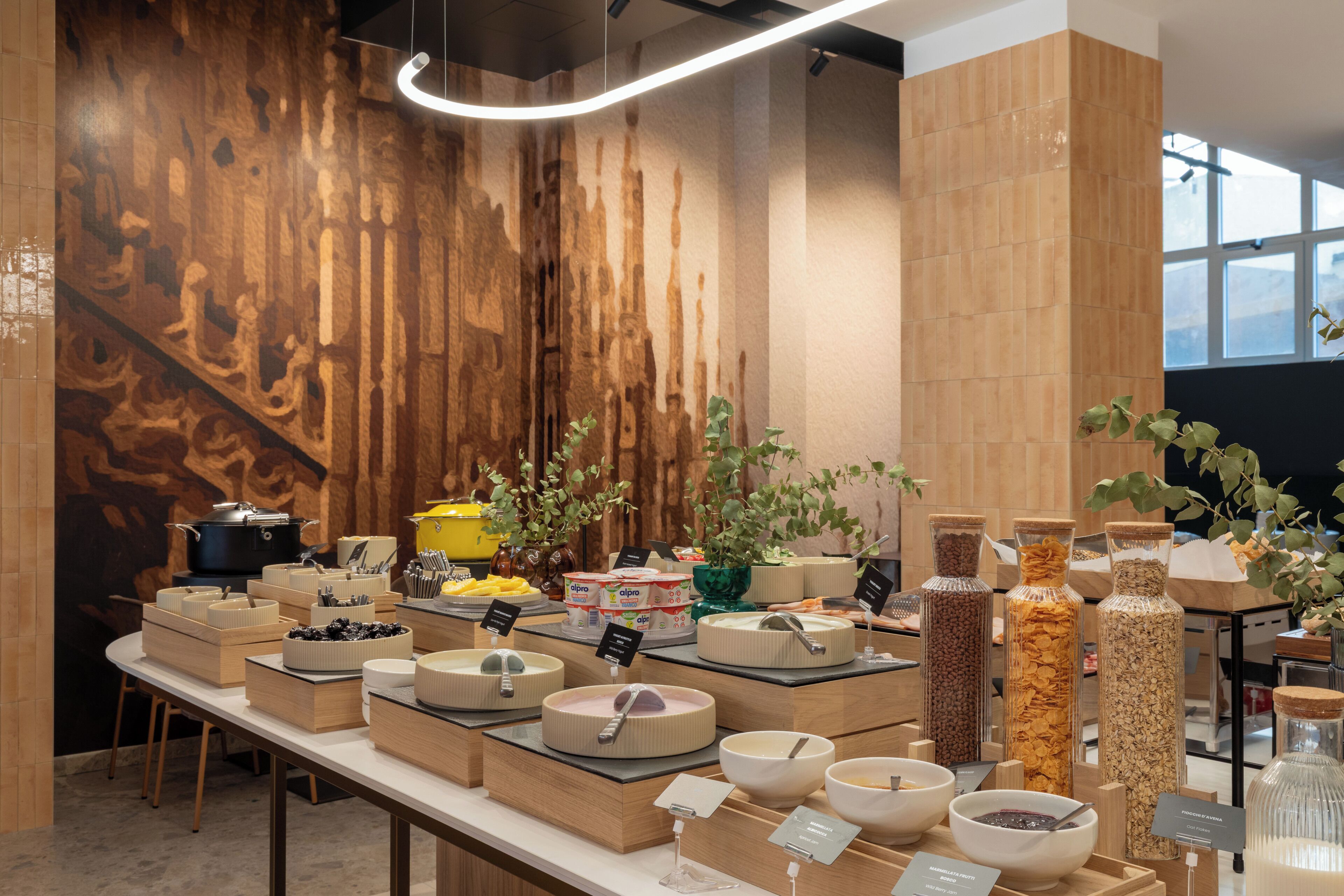A buffet setup with various food containers and a wooden wall backdrop.