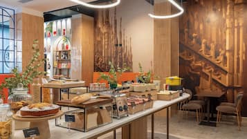 Un buffet per la colazione con diversi cibi e un angolo caffè.