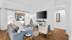 Ein modernes Wohnzimmer mit einer Couch, einem Couchtisch und einem Fernseher.