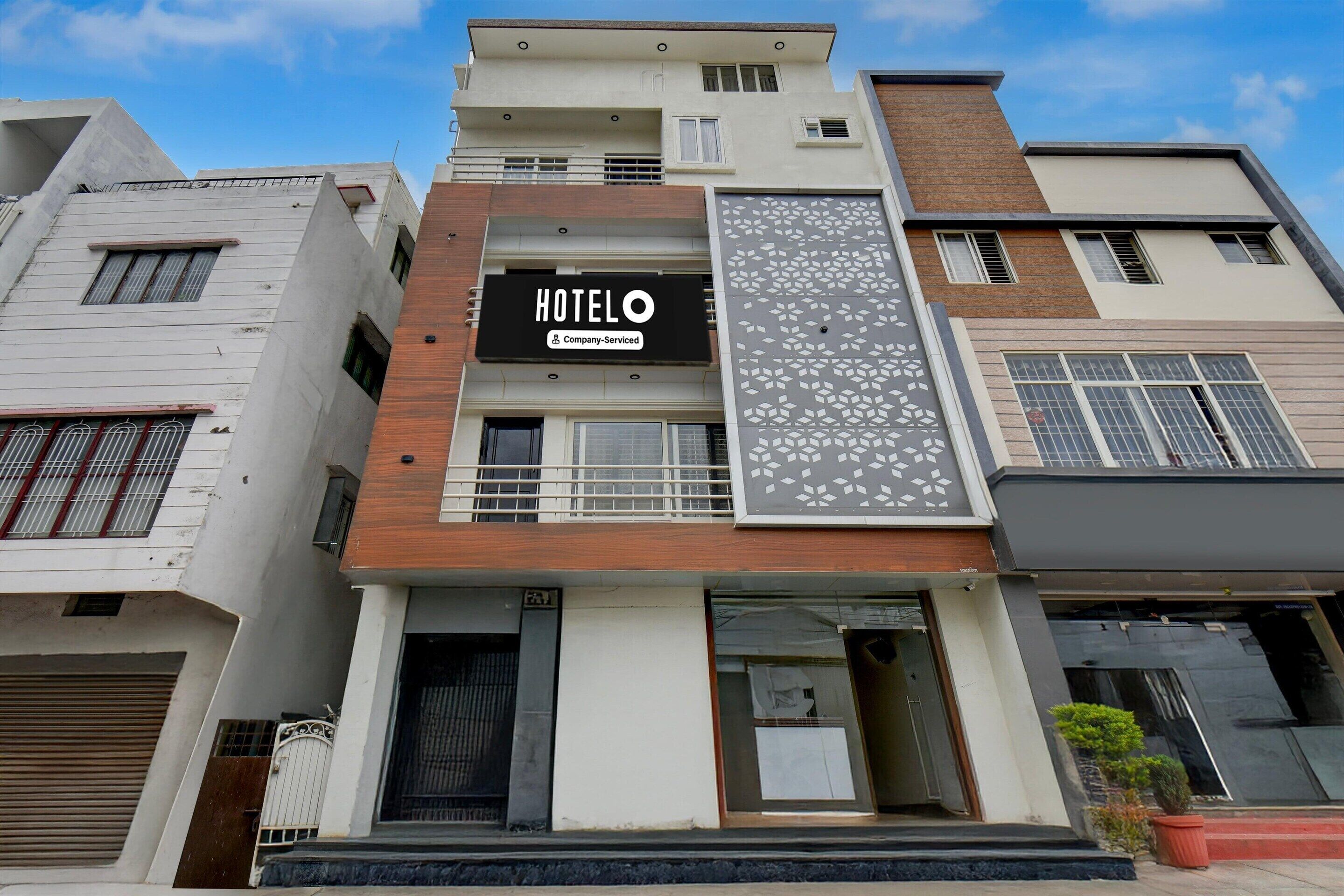 Ein Hotel mit moderner Fassade, einem gut sichtbaren 'HOTELO'-Schild und einer strukturierten Dekoration.