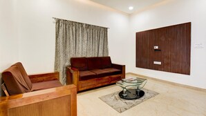 Ein modernes Wohnzimmer mit einer Holzsofa, einem Glastisch und einer Wand mit Holzvertäfelung.