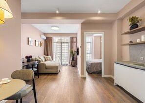Un apartamento moderno con sala de estar, comedor, kitchenette y un dormitorio.