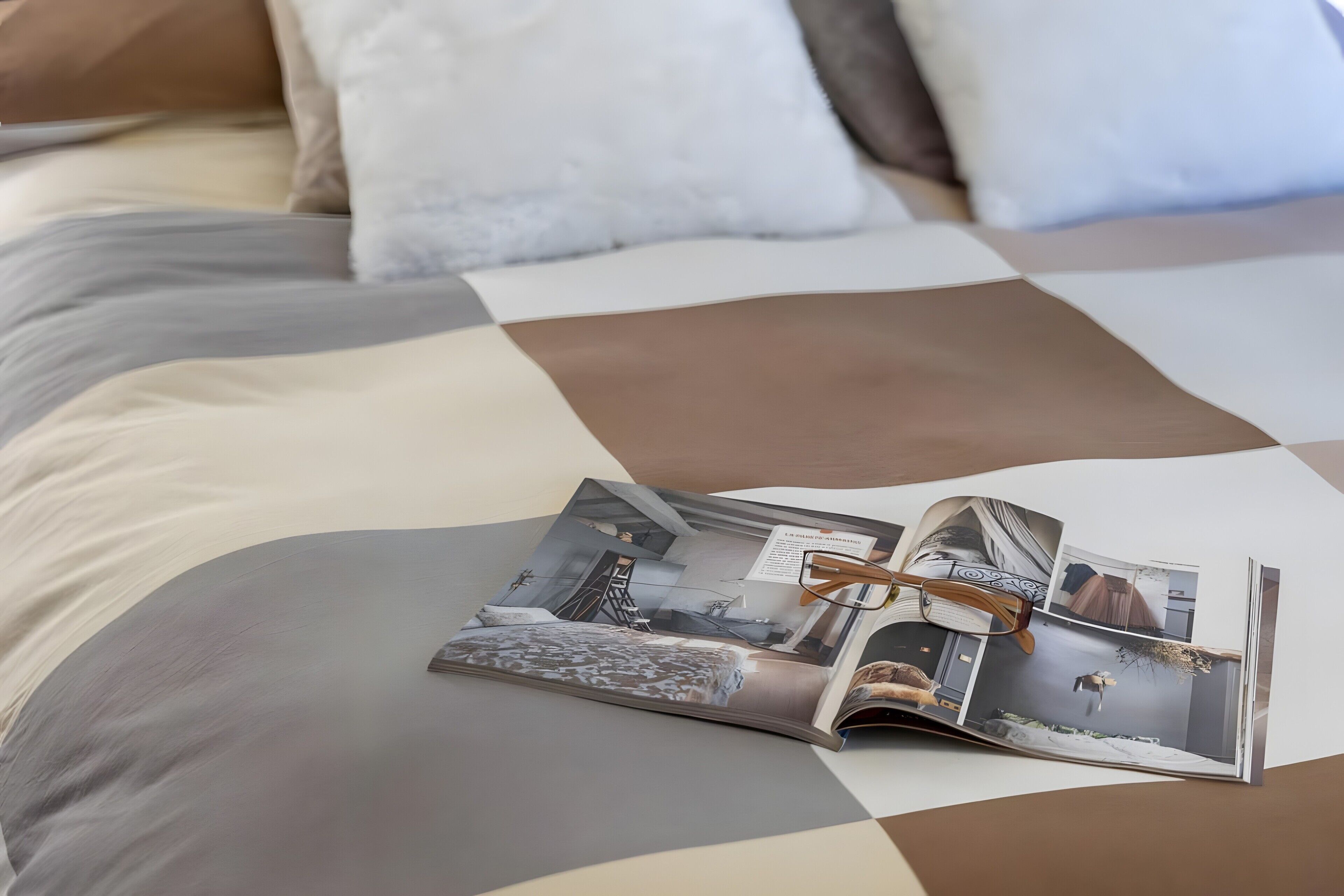 Una revista sobre la cama, con una colcha a cuadros.