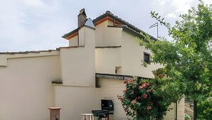 A hot tub in a backyard with a building in the background. - Apartment with Garden and Jacuzzi in Mugello (Barberino di Mugello)