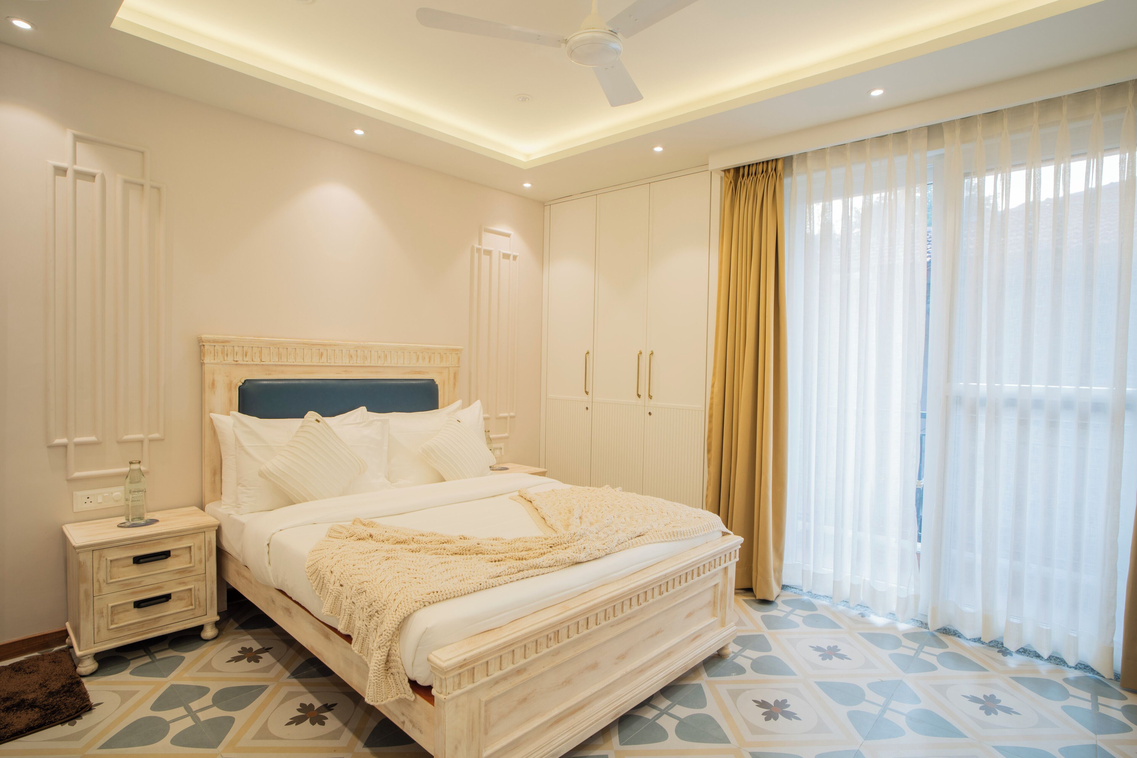 A bedroom with a bed, nightstand, wardrobe, and a ceiling fan.