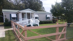 Zona residencial con una casa, un deck de madera y un patio cercado.