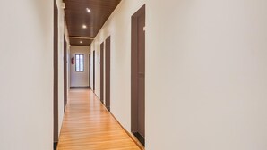 A long, narrow hallway with wooden flooring and white walls.