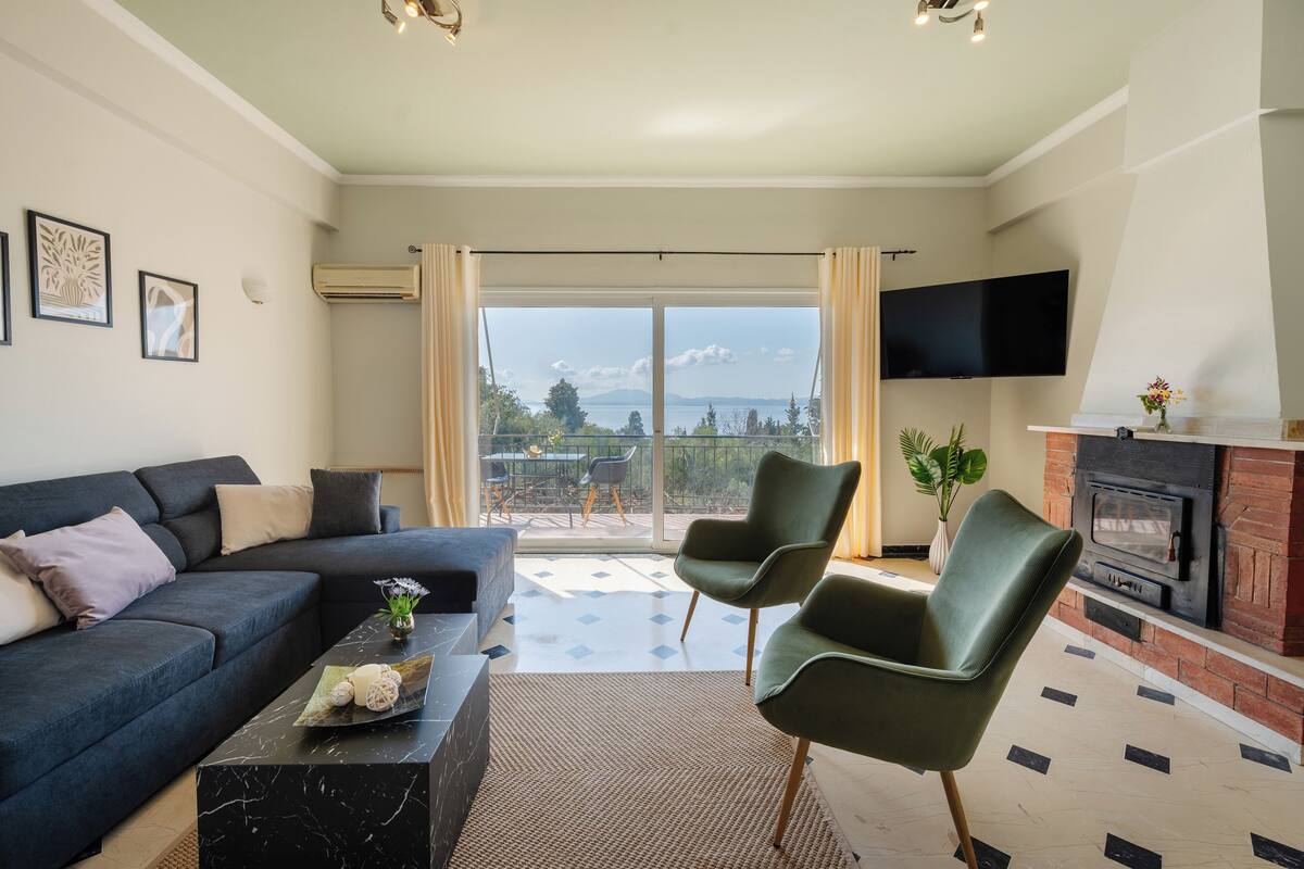 A living room with a sofa, chairs, a fireplace, and a TV.