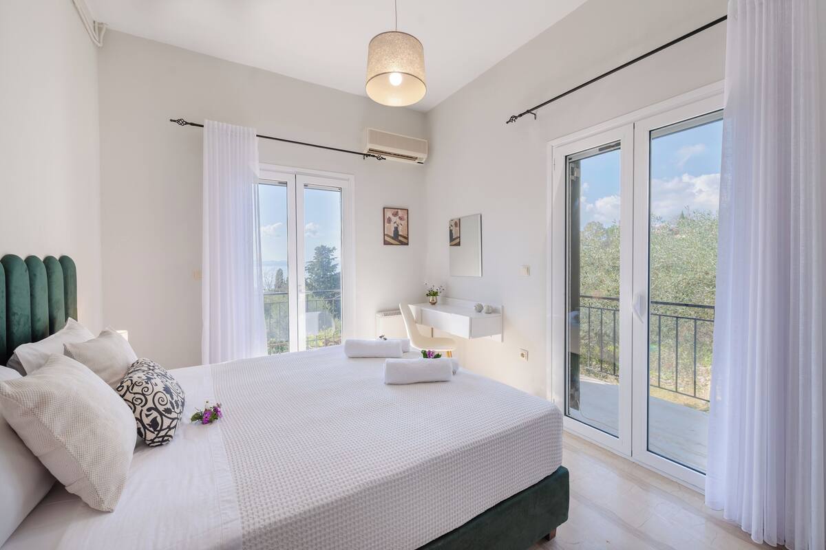A modern bedroom with a large bed, a ceiling light, a window, and a balcony.