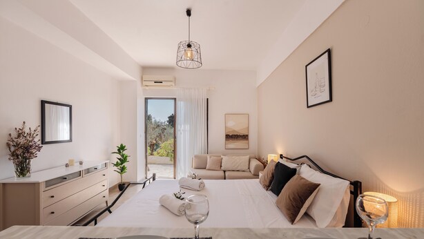 Una habitación de hotel moderna con cama, mesita de noche y vistas al exterior.