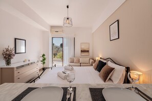 A modern hotel room with a bed, bedside table, and a view of the outdoors. - The 7 Trees Apartments by Konnect, Nisaki (Corfu)
