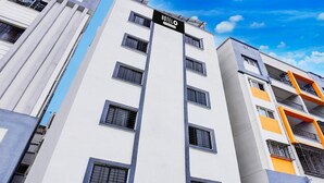 A multi-story hotel building with a sign indicating it is a hotel. - Classic With Twin Bedspot Light Lodging (Pune)