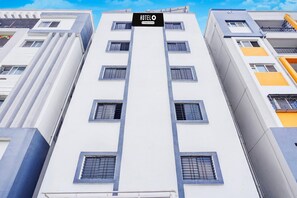 Un edificio alberghiero a più piani con un cartello che riporta 'HOTELO' e il nome di una compagnia.
