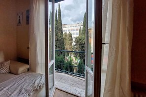 A bedroom with a bed, a window, and a balcony with a railing. - Aventino - Nice and cozy apartament for 4 close to the Circo Massimo (Roma)