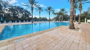 A swimming pool with lounge chairs and palm trees. - Brand New Home at Reunion Resort - Near Disney (Kissimmee)