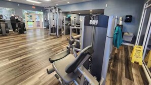 A gym with exercise equipment, wooden flooring, and a blue wall. - Brand New Home at Reunion Resort - Near Disney (Kissimmee)