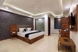 A modern bedroom with a bed, bedside tables, a desk, a chair, a ceiling fan, and a TV mounted on the wall. - OPO Horizon Vertu (New Delhi)