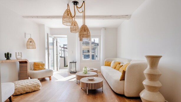 Uma sala de estar moderna com sofá, pufe e mesa de centro redonda.