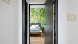 A bedroom with a bed, a bedside table, and a nightstand. - Room “Birke” with Shared Garden and Wi-Fi (Vogtsburg im Kaiserstuhl)