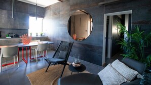 A modern interior with a dining area, seating, and a large mirror. - C-Home Otranto – Design Apartment with Panoramic Terrace (Otranto)