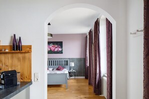 A bedroom with a bed, a nightstand, a lamp, and a radiator.